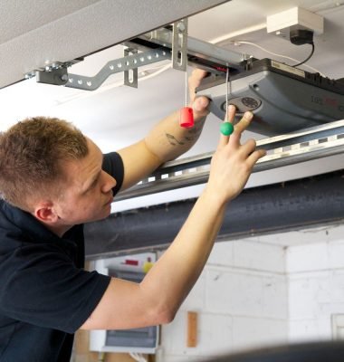 A man is working in Garage door electrical Lock.